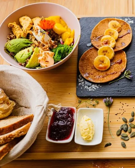 Brunch with a poke bowl, banana pancakes and a basket of breads