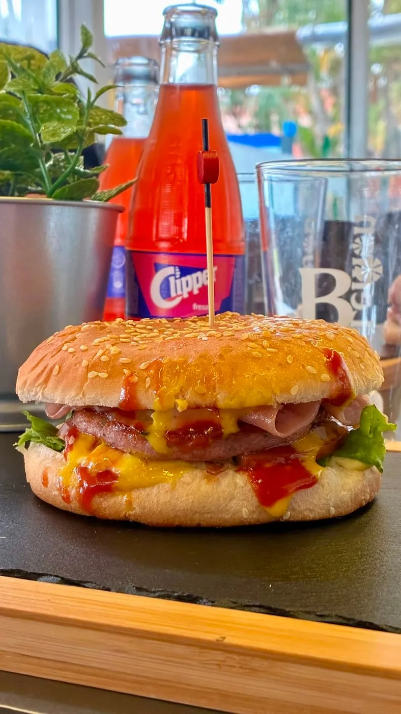 Classic childhood burger, with a strawberry Clipper soda beside it