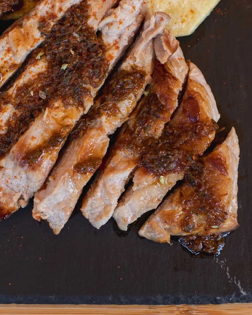 Pata asada cortada en lonchas sobre laja