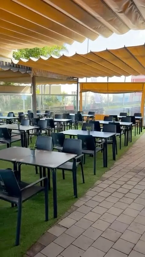 The covered terrace, tables laid before opening
