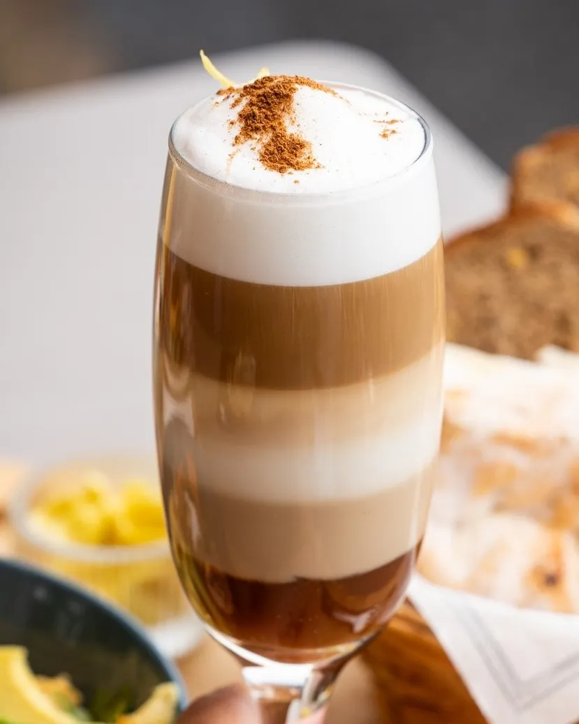 Zaperoco served in a tall glass, layered with coffee, condensed milk and cream